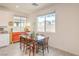 Dining area features a wooden table, wood floors, and large bright windows at 7045 Judith River St, North Las Vegas, NV 89084