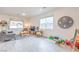 Cozy living room featuring wood-look floors, a large clock and bright, natural light at 7045 Judith River St, North Las Vegas, NV 89084