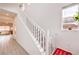 Bright staircase with white railing, carpeted steps, and natural light from a window at 7045 Judith River St, North Las Vegas, NV 89084