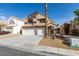 Two-story home featuring a three-car garage, desert landscaping, and mature trees, plus a tile roof at 71 Sea Holly Way, Henderson, NV 89074