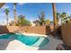Backyard featuring a private pool with a rock waterfall, landscaping, and tall palm trees under a sunny sky at 71 Sea Holly Way, Henderson, NV 89074