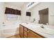Bathroom features a tub, double sinks, window, and nice lighting at 735 Wolf Point St, Henderson, NV 89002
