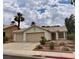 Charming single-story home with a three-car garage, desert landscaping and lush palm trees at 735 Wolf Point St, Henderson, NV 89002