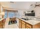 Cozy kitchen featuring tile floors, granite countertops, and oak cabinets next to a dining area with lots of light at 735 Wolf Point St, Henderson, NV 89002
