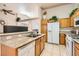 Spacious kitchen featuring granite countertops, white appliances, and oak cabinets with a breakfast bar overlooking the living area at 735 Wolf Point St, Henderson, NV 89002