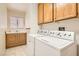 Functional laundry room with washer, dryer, sink, and overhead cabinets at 735 Wolf Point St, Henderson, NV 89002
