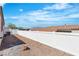 Narrow backyard with gravel, white fencing, and view of surrounding neighborhood at 7820 Milkweed Ct, Las Vegas, NV 89149