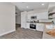 Modern kitchen featuring stainless steel appliances, white cabinets, and wood-look floors at 7820 Milkweed Ct, Las Vegas, NV 89149