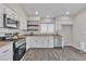 Well-lit kitchen featuring stainless steel appliances, tile backsplash, and wood-look floors at 7820 Milkweed Ct, Las Vegas, NV 89149