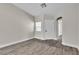 Bright living room with wood-look floors, a window, and an arched entry at 7820 Milkweed Ct, Las Vegas, NV 89149