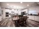 Open concept dining and kitchen area featuring wood floors, white cabinets, granite countertops, stainless appliances, and pendant lighting at 8 Via Dolcetto, Henderson, NV 89011