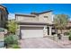 Inviting two-story house boasts a two-car garage, brick driveway, gated entry, and desert landscaping at 8 Via Dolcetto, Henderson, NV 89011