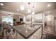 A spacious kitchen with a large island, stainless steel appliances, and pendant lighting with an open concept to the dining area at 8 Via Dolcetto, Henderson, NV 89011