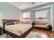 Bedroom with wood floors, a large bed, side table, and decorative curtains and chaise lounge at 8777 Shady Peak Way, Las Vegas, NV 89123