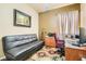 Functional home office with a sleek black futon, desk, and chair, perfect for remote work or study at 8777 Shady Peak Way, Las Vegas, NV 89123