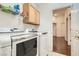 Convenient laundry room featuring a washer, dryer, storage cabinets and hardwood floors in the hallway at 8777 Shady Peak Way, Las Vegas, NV 89123