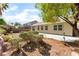 A backyard with a patio, trees, bushes, and grass at 908 Cypress Gold Ct, North Las Vegas, NV 89031