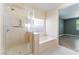Updated shower and soaking tub in bright bathroom with large window and neutral color palette at 908 Cypress Gold Ct, North Las Vegas, NV 89031
