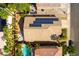 Birds-eye view of a home with solar panels, palm trees, a pebble patio and a turquoise pool at 922 Lloyd George Dr, Henderson, NV 89052