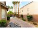 Beautifully landscaped backyard with a brick-paved patio, tall palm trees, and lush greenery at 922 Lloyd George Dr, Henderson, NV 89052