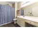 Bathroom featuring a single sink vanity, decorative mirror, and a shower with blue patterned curtain at 922 Lloyd George Dr, Henderson, NV 89052