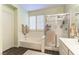 Clean bathroom with tub, shower, white tile surround, plantation shutters, and wood look flooring at 922 Lloyd George Dr, Henderson, NV 89052