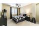 A neat bedroom featuring a dark wood dresser and modern ceiling fan with dark window treatments at 922 Lloyd George Dr, Henderson, NV 89052
