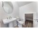 Well-lit bathroom with modern pedestal sink and separate storage at 9314 Observatory St, Las Vegas, NV 89143