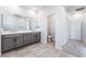 Bathroom featuring a double vanity with gray cabinetry, light tile floors and neutral decor at 9314 Observatory St, Las Vegas, NV 89143