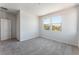Bedroom with soft carpet, a modern door, and windows with views of the mountains and neighborhood at 9314 Observatory St, Las Vegas, NV 89143