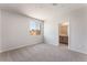 Carpeted bedroom showing a bathroom entrance, a window view, and neutral wall color at 9314 Observatory St, Las Vegas, NV 89143