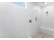 Walk-in shower features stylish white tiling, a built-in shower bench, and a modern shower head at 9314 Observatory St, Las Vegas, NV 89143