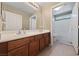 Bathroom featuring double sinks with wood cabinets, a large mirror, and a shower/tub combo at 9393 New Utrecht St, Las Vegas, NV 89178