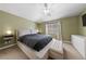 Main bedroom with a cozy bed, bedside tables, a window, and dresser at 9393 New Utrecht St, Las Vegas, NV 89178