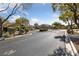 Gated entrance to a community with well-maintained landscaping and mature trees at 9393 New Utrecht St, Las Vegas, NV 89178