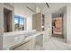 Bright bathroom showcasing marble countertops, modern fixtures, and a large window with city views at 1 Hughes Center Dr # 1901, Las Vegas, NV 89169