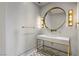 Modern powder room with marble vanity, gold fixtures, round mirror and decorative tile flooring at 1 Hughes Center Dr # 1901, Las Vegas, NV 89169