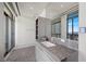 Modern bathroom with sleek vanity, a large mirror, and a stunning city view through the window at 1 Hughes Center Dr # 1901, Las Vegas, NV 89169