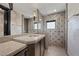 Modern bathroom featuring a glass shower, granite countertops, and decorative wallpaper at 1 Hughes Center Dr # 1901, Las Vegas, NV 89169
