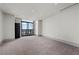 Bedroom featuring carpet, neutral walls, modern lighting, balcony access, and city views at 1 Hughes Center Dr # 1901, Las Vegas, NV 89169