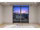 Modern bedroom featuring floor-to-ceiling windows with a stunning view of the Las Vegas skyline at sunset at 1 Hughes Center Dr # 1901, Las Vegas, NV 89169