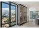 Bright living area featuring expansive city views through floor-to-ceiling windows and a modern built-in cabinet at 1 Hughes Center Dr # 1901, Las Vegas, NV 89169