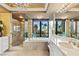 Luxury bathroom with marble tile, glass shower, chandelier, and garden soaking tub at 1 Hughes Center Dr # 308, Las Vegas, NV 89169