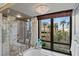 A luxury bathroom featuring a glass shower and large window offering cityscape views at 1 Hughes Center Dr # 308, Las Vegas, NV 89169