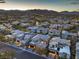 An aerial view shows the tile roofs of modern homes nestled in the desert with picturesque mountain views at 10 Sugarberry Ln, Las Vegas, NV 89135