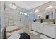 Elegant bathroom with marble tile, dual sinks, soaking tub, and walk-in shower at 10484 Rose Park Ave, Las Vegas, NV 89135