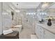 Bright bathroom with marble tile, soaking tub, walk-in shower, and dual sinks at 10484 Rose Park Ave, Las Vegas, NV 89135