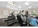 Well-equipped gym offers various machines, natural light, and ceiling fans for comfortable workouts at 10484 Rose Park Ave, Las Vegas, NV 89135