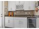 Elegant bar area featuring white cabinetry, granite counters, and a wine cooler at 1073 Via Della Costrella, Las Vegas, NV 89101