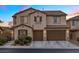 Two-story home features a two-car garage, tan stucco, and a red tile roof at 1073 Via Della Costrella, Las Vegas, NV 89101